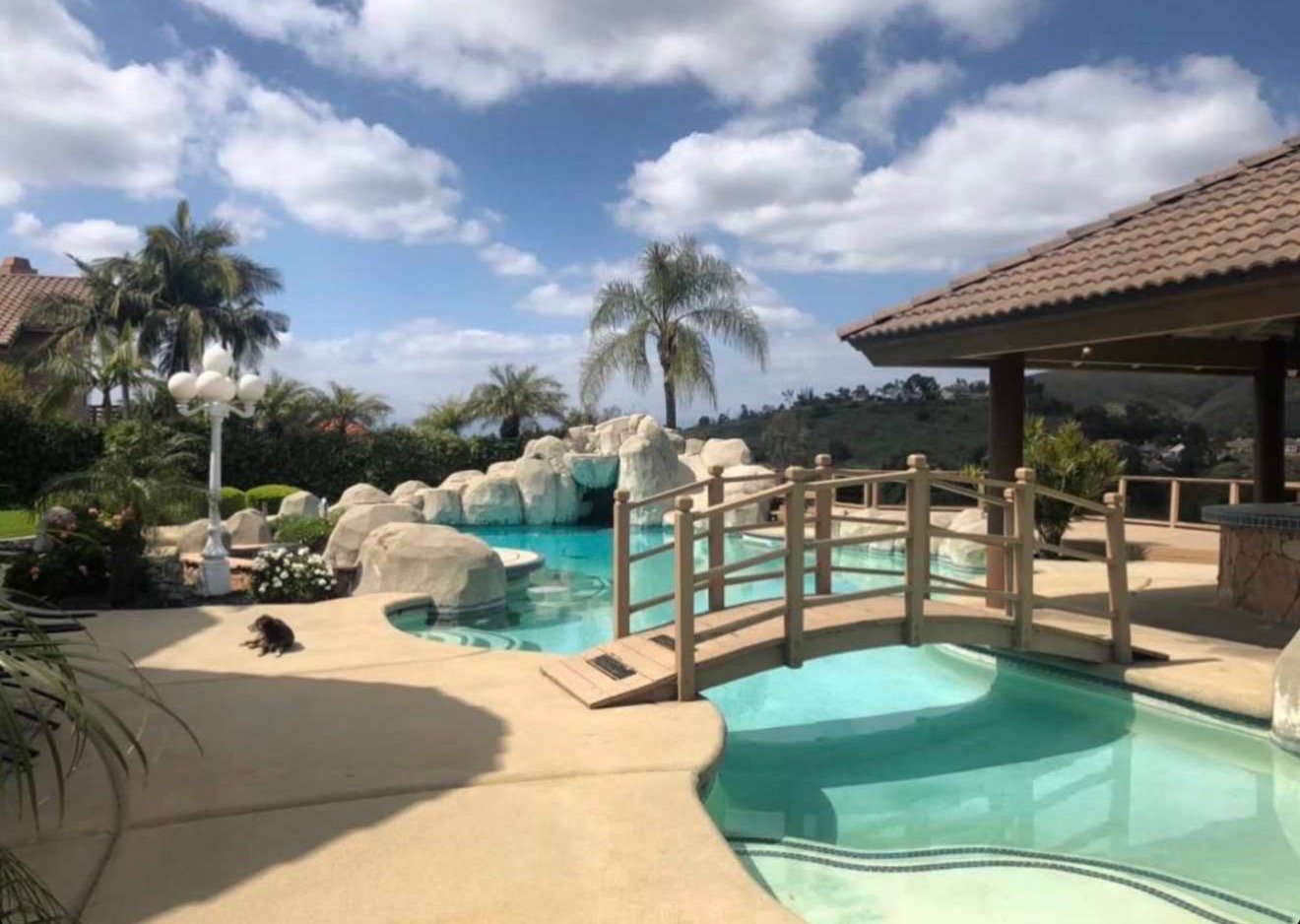 Poolside venue — arched wooden bridge over a daytime pool
