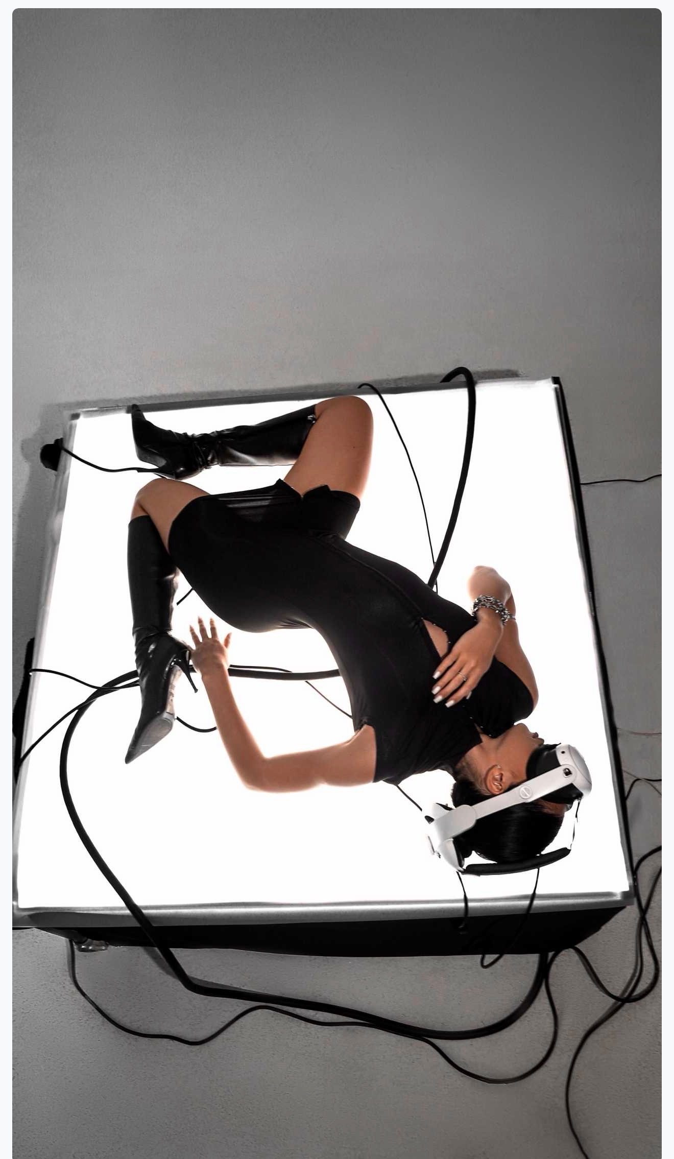Model posing on a glowing lightbox table on one of the studio sets